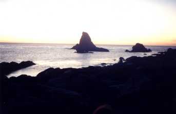 Dramatic rock in the bay at sunset