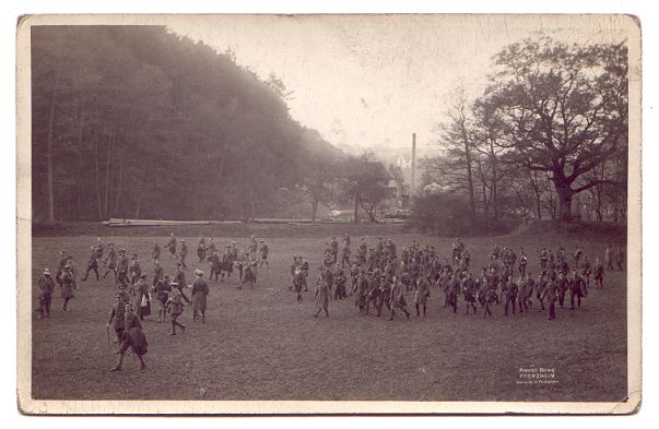 A large crowd strolls across the wide grassy entrance to the valley.