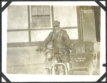 A WRAF motorcycle driver sits on a motorbike which has a sidecar attached.