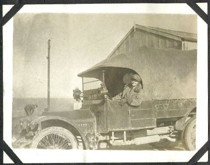 A WRAF driver at the wheel of a canvas-topped truck.