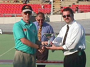 Club Secretary and assistant coach Bill Gibson receives the Division 1 North Trophy at half time for the Senators.
